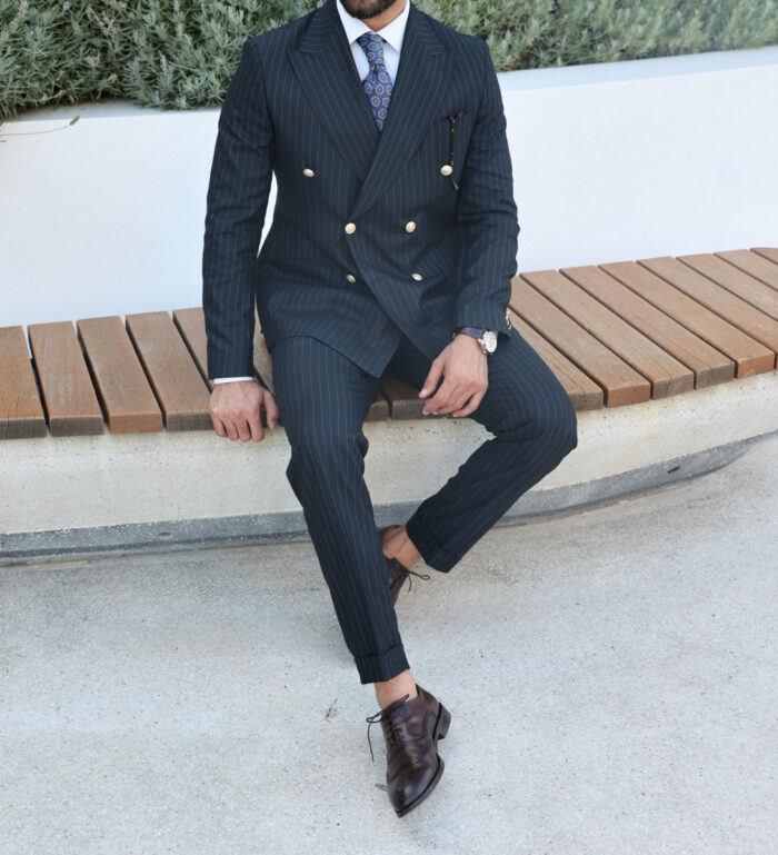 Hitters Lane Tailored slim fit dark blue pinstripe double breasted two piece suit with peak lapels with  decorative gold buttons.