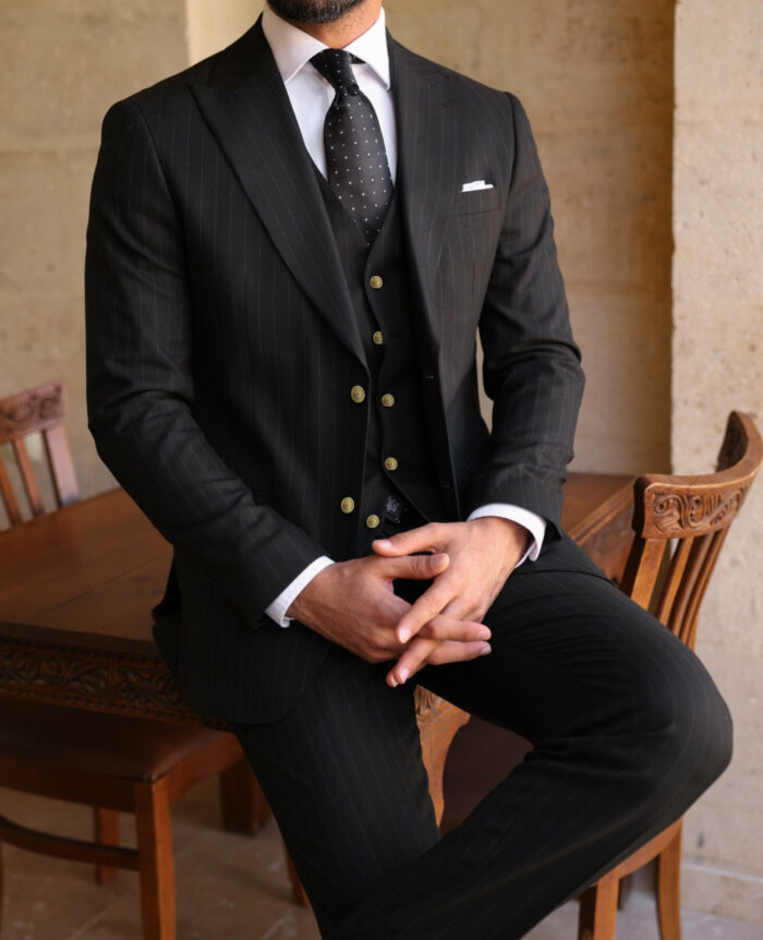 Bales Court Slim fit black men’s three piece suit with peak lapels and with decorative gold buttons